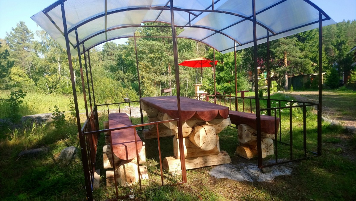 Беселка на берегу с рубленым столом